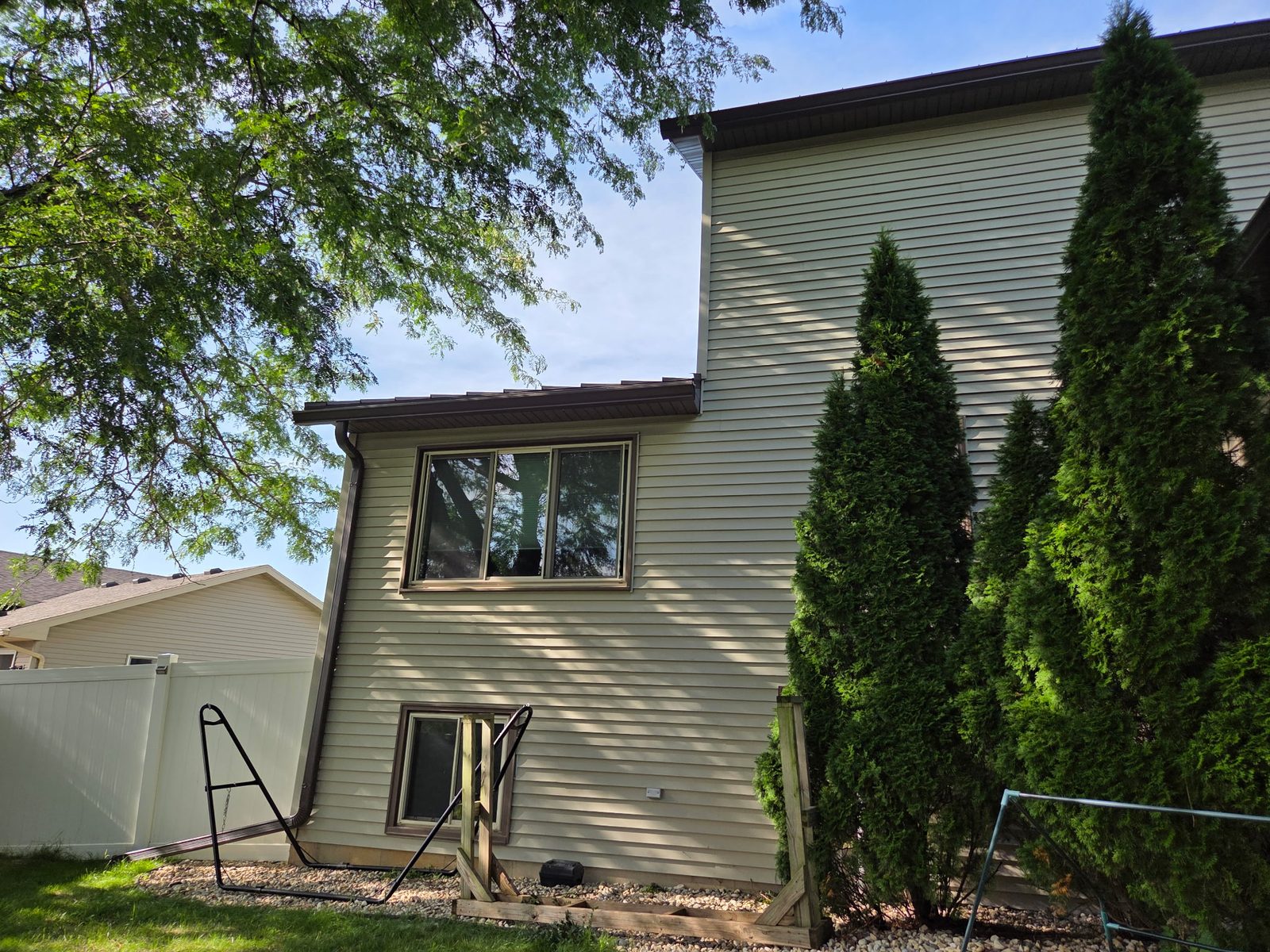 Back of a two-story home with a new full-height downspout run and gutters