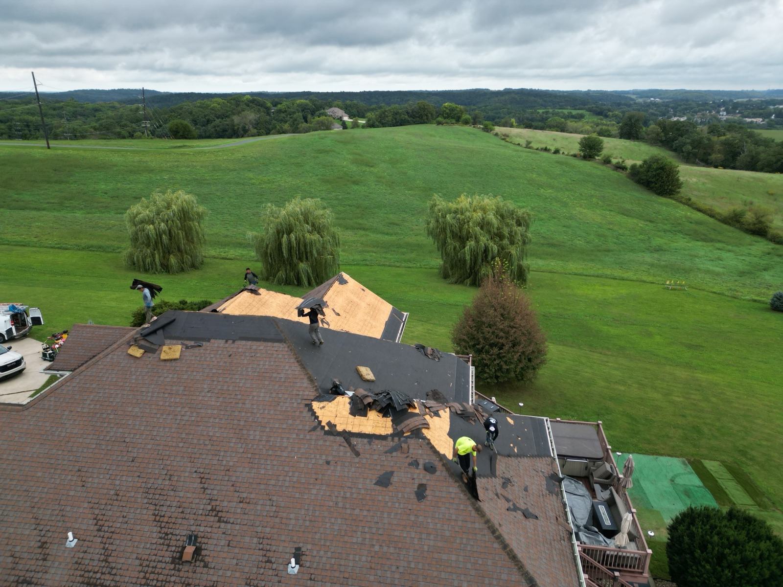 Tear-off at the roof edge with open farm fields beyond